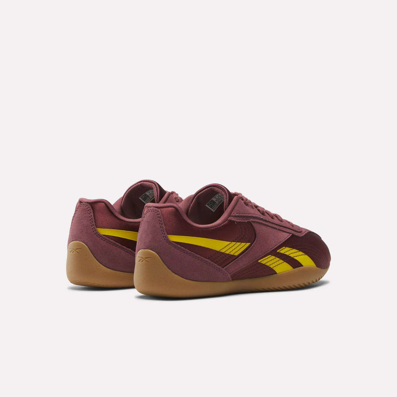 The Reebok Women's Ultra Lo Shoes, maroon with yellow stripes and gum soles, are shown against a plain white background from the back and side angles.