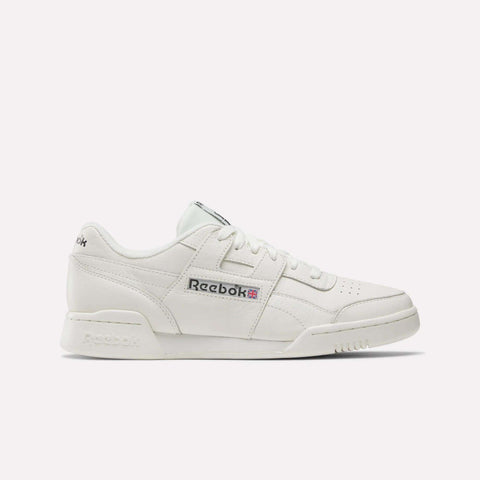 The Reebok Workout Plus Shoes are white sneakers with classic '80s fitness style, a lace-up front, perforated toe, and Reebok logo with Union Jack on the side, shown against a plain light background.