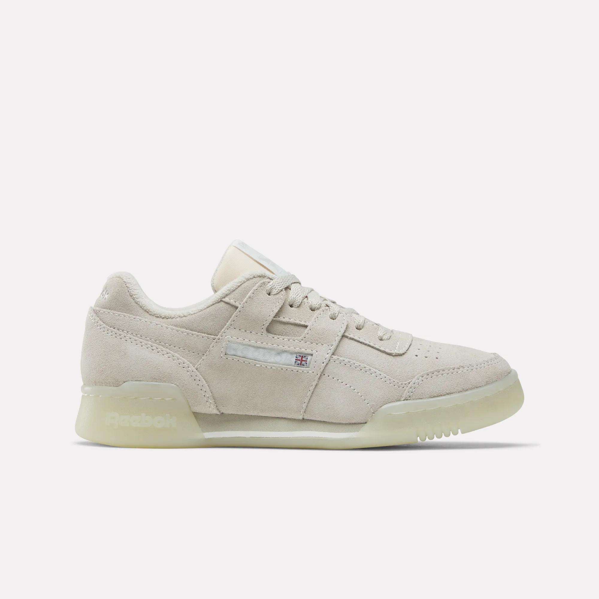 The Reebok Women's Workout Plus Shoes feature beige suede, a low profile, subtle side branding, and a translucent sole—bringing retro '80s fitness style to classic women's workout footwear. Shown on a plain white background.