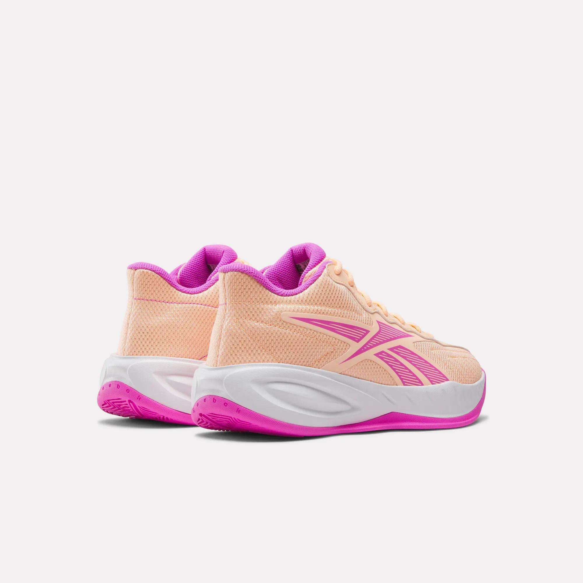 The Reebok Press Basketball Shoes in peach with pink detailing feature white midsoles, pink outsoles, and responsive EVA cushioning for all-day comfort. Shown from the back and side on a white background.