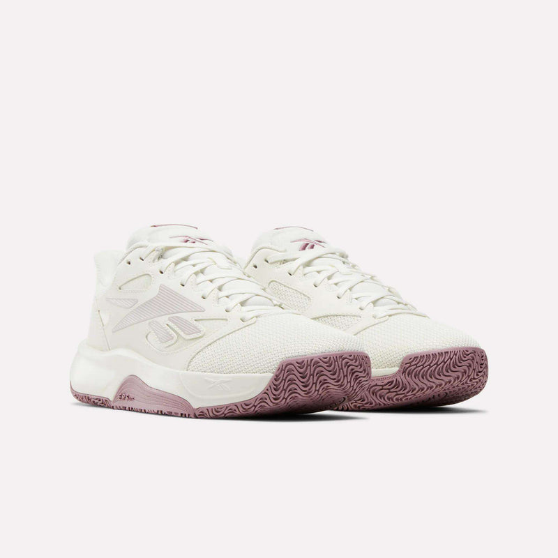 A pair of Reebok Engine LT Shoes in white with light pink accents and textured mauve soles, shown on a plain white background.