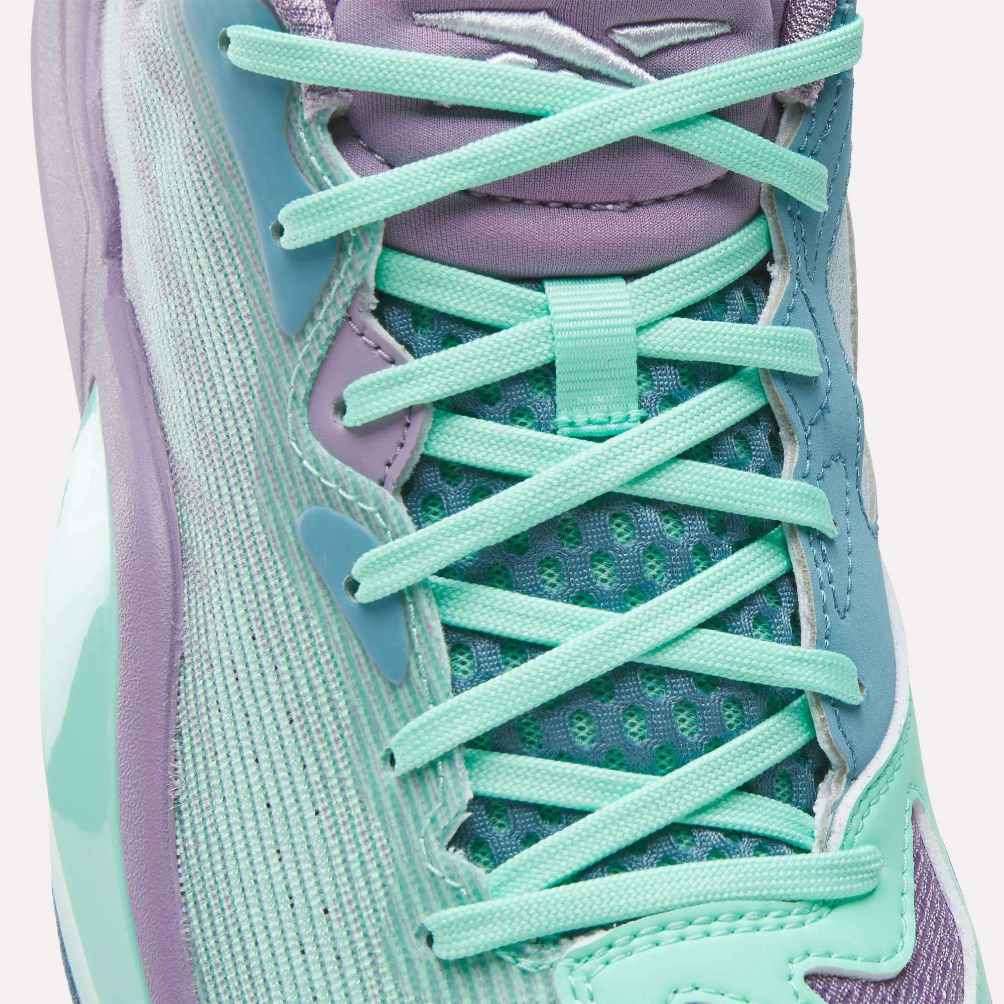 Close-up of Reebok Engine A 26 Basketball Shoes, featuring teal and lavender hues, mint green laces, mesh tongue, and a glossy textured side with gradients for enhanced style and stability—ideal support for basketball players.
