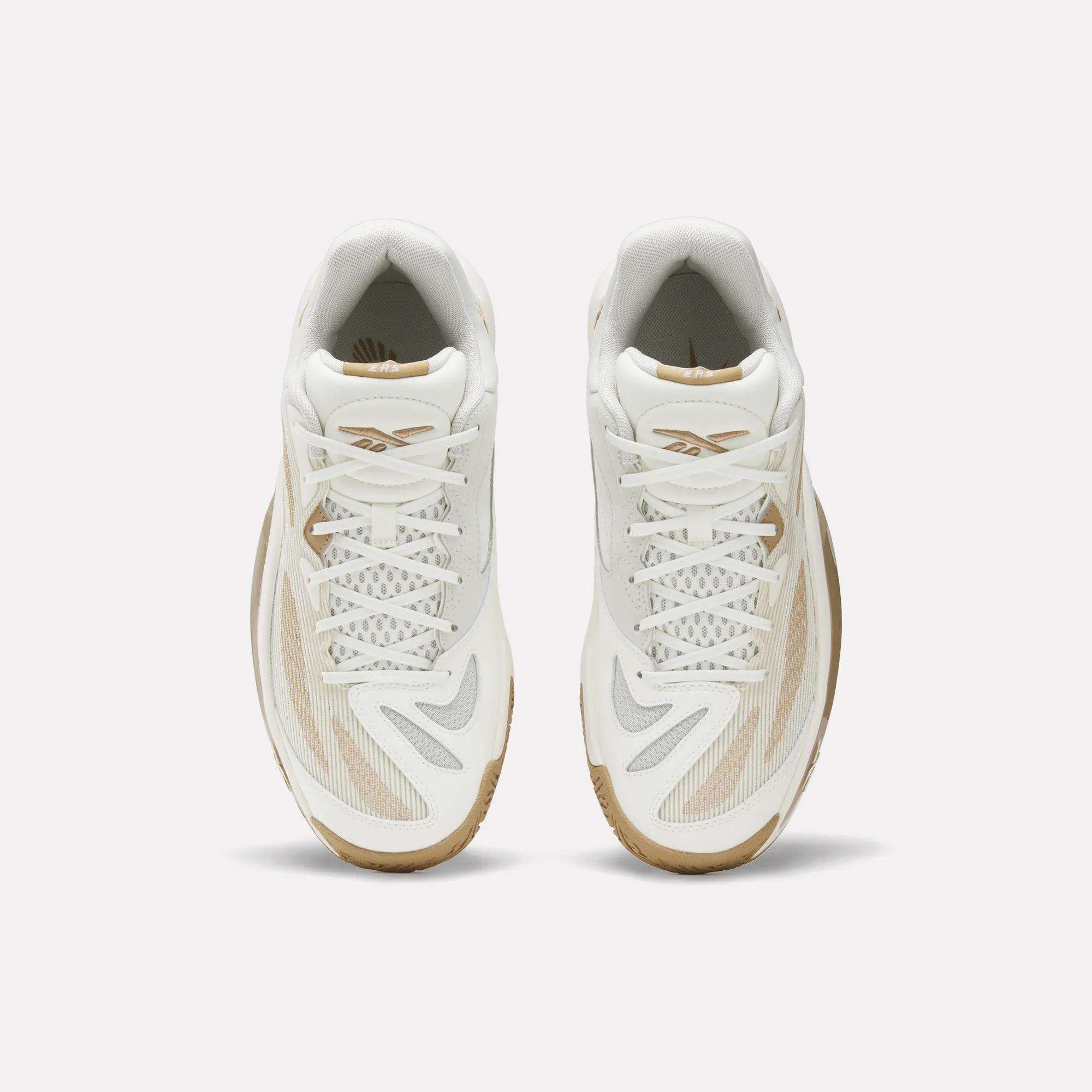 Top view of Reebok Engine A 26 Basketball Shoes: white athletic sneakers with beige and gray accents, mesh and synthetic details, white laces for stability and energy return, plus light brown rubber soles on a plain white background.