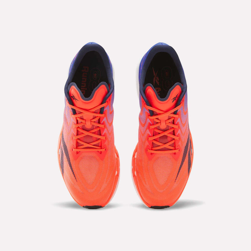 A pair of Reebok SpeedShifter Running Shoes in vibrant orange with purple accents is shown from an overhead perspective on a white background. These shoes feature visible laces, a breathable mesh upper, and incorporate HyperFloat foam for improved comfort and performance.