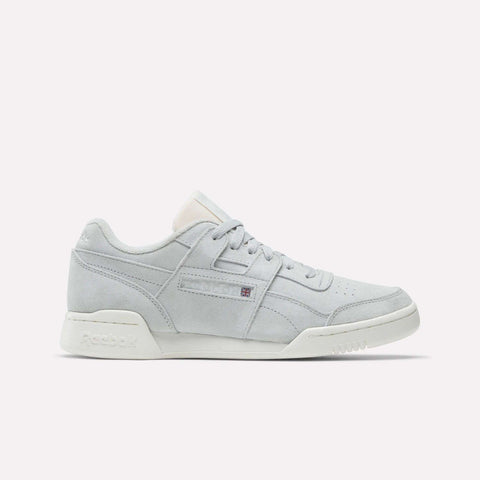 The Reebok Workout Plus Shoes feature a light gray suede finish, white sole, and subtle side branding. Displayed in side profile on a plain white background, they evoke classic '80s fitness style.