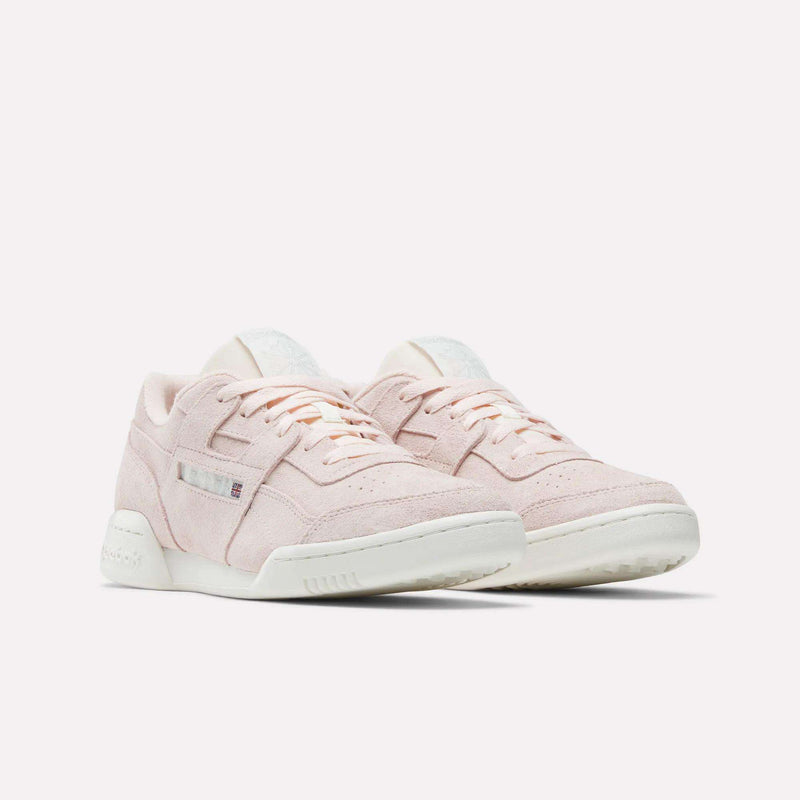 The Reebok Workout Plus Shoes in light pink suede feature white soles and discreet side and heel branding, capturing '80s fitness vibes. Displayed against a plain white background.
