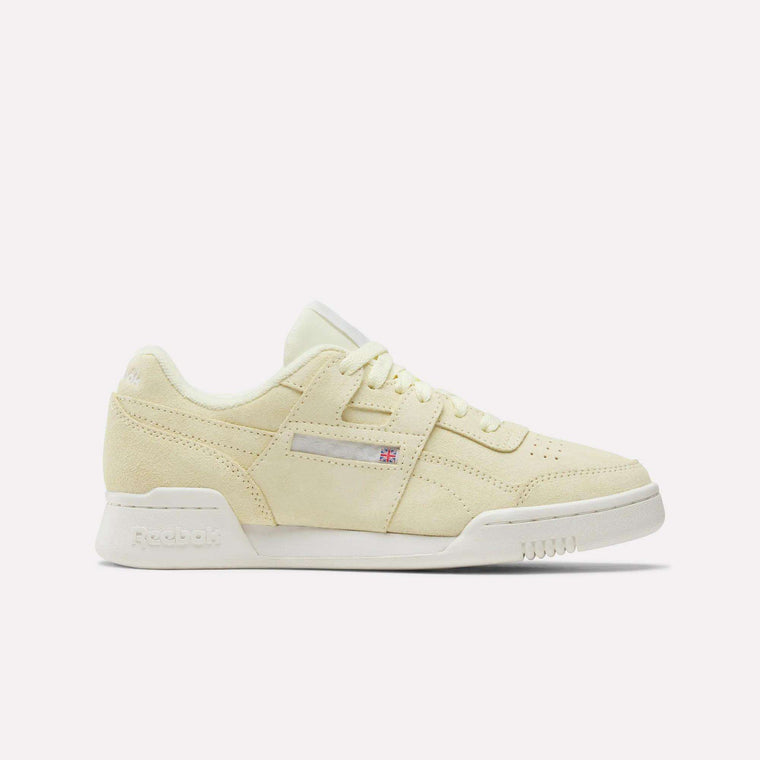 The Reebok Women's Workout Plus Shoes feature a beige suede finish, white sole, and tonal laces, shown in side profile against a white background—a classic '80s-inspired sneaker for women's fitness style.