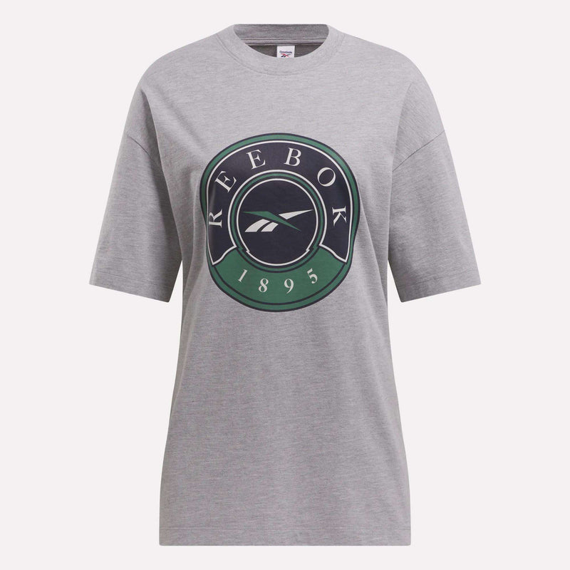 The Women's Lawn Club T-Shirt by Reebok is a gray cotton knit tee with a luxe feel, featuring a large circular logo and "REEBOK 1895" in green, white, and black on the front.