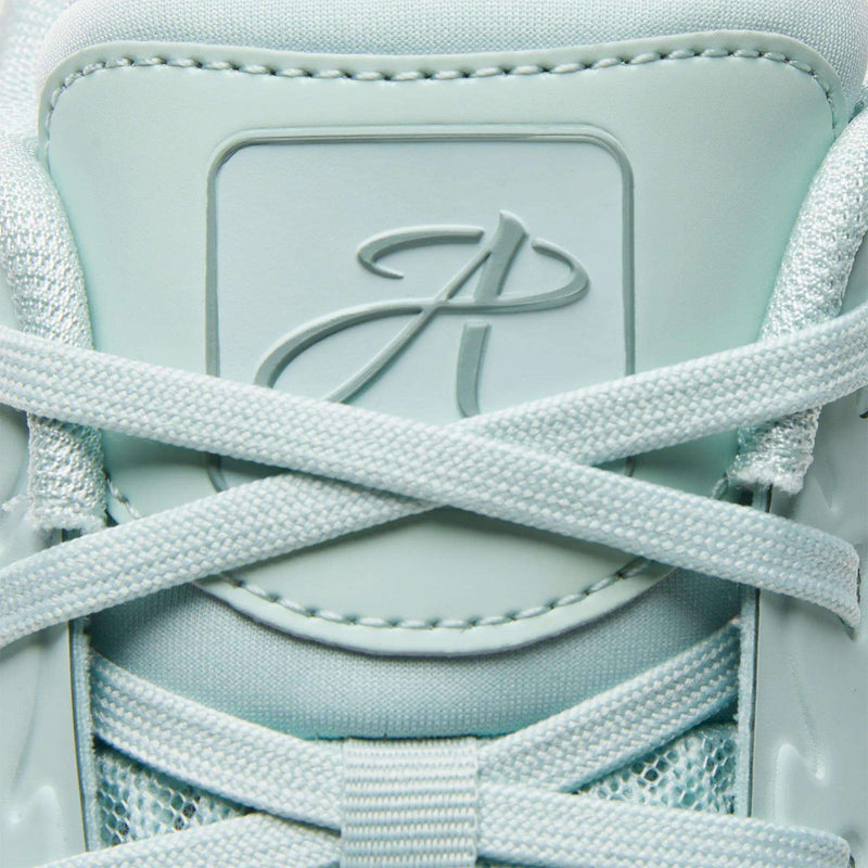 Close-up of the light blue Reebok Angel Reese 1 Basketball Shoes featuring crisscrossed laces and an embossed P logo on the tongue. The visible texture highlights the Energy Return System for added comfort.