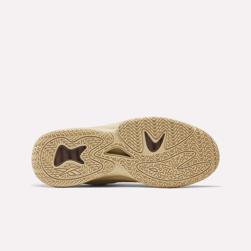 The bottom of the Angel Reese 1 Basketball Shoes by Reebok features a beige outsole with wavy, textured tread and cutout sections for grip and flexibility—perfect for performance on the basketball court.