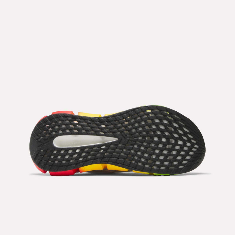 The image shows the black rubber outsole of Reebok Women's FloatZig 2 SoleMates Running Shoes, featuring a grid-patterned tread and red, yellow, and green accents. A lightweight foam midsole adds comfort for performance running.