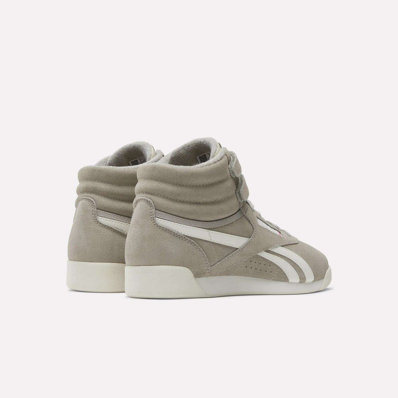 The Reebok Women's F/S Hi Shoes are light gray high-top sneakers with suede uppers, white soles, and side stripes, shown angled to display the back and side against a plain background.