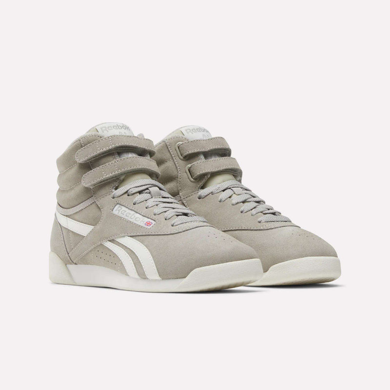 The Reebok Women's F/S Hi Shoes feature a light gray suede upper, padded ankles, double velcro straps, white side stripes, and white soles, shown against a plain white background.