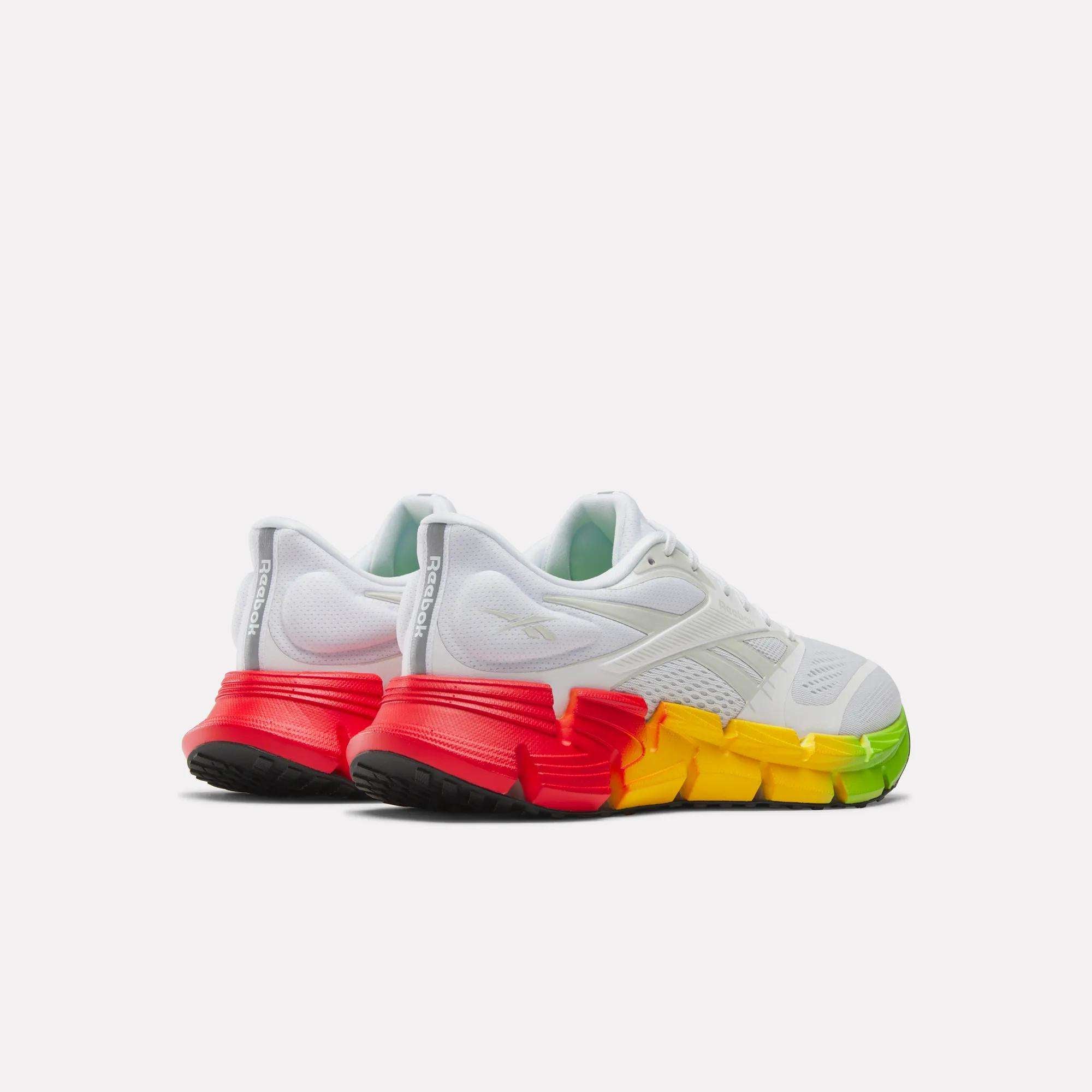 The Reebok Men's FloatZig 2 SoleMates Running Shoes are white with thick, segmented soles fading from green to red at the heels. They feature a lightweight foam midsole, sleek design, and black outsoles for top performance.