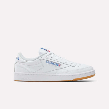 The Men's Club C 85 Shoes by Reebok are white leather low-tops with blue and red Reebok logos on the side and a light brown rubber sole, shown on a plain white background. These tennis-inspired sneakers offer classic style and comfort.