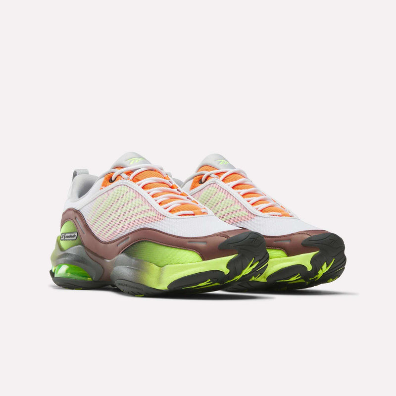 The Reebok DMX Series 3000 Shoes feature white, brown, and green mesh uppers, bright orange laces, neon green accents, black soles, and a chunky modern design with DMX moving air technology for extra comfort.