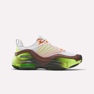 The Reebok DMX Series 3000 Shoes feature a white upper with pink and orange accents, brown details, and a neon green and black sole. Shown in a side view, these sneakers offer comfort thanks to DMX moving air technology.