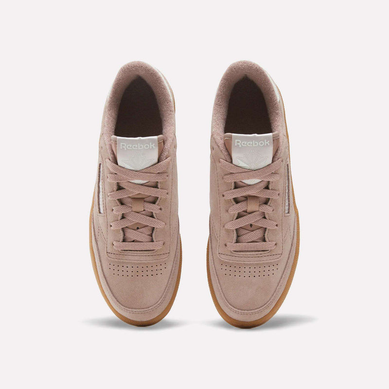 A pair of Women’s Club C 85 Shoes by Reebok in light pink, featuring soft suede uppers and gum soles, displayed from above on a plain white background.