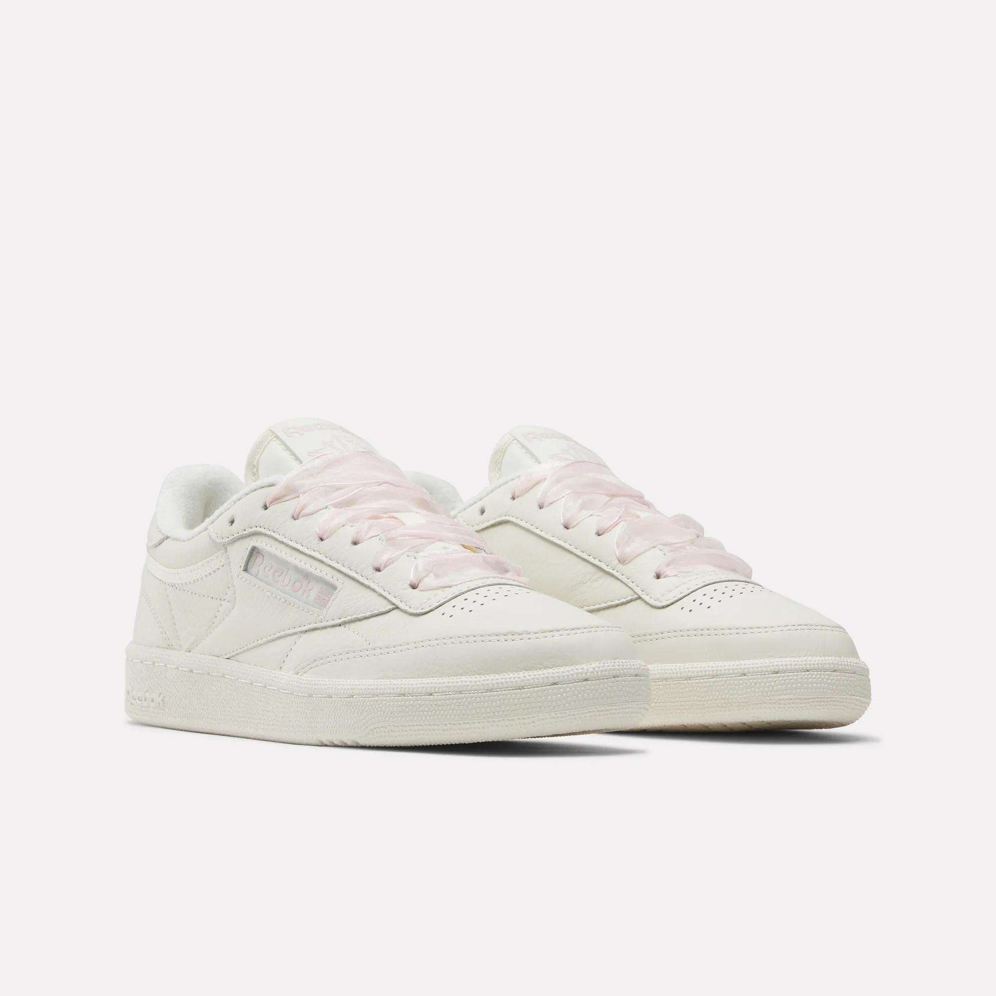 The Reebok Women's Club C 85 Vintage Shoes feature off-white leather, light pink laces, and classic low-top design with subtle branding, offering versatile vintage style. Shown against a white background.