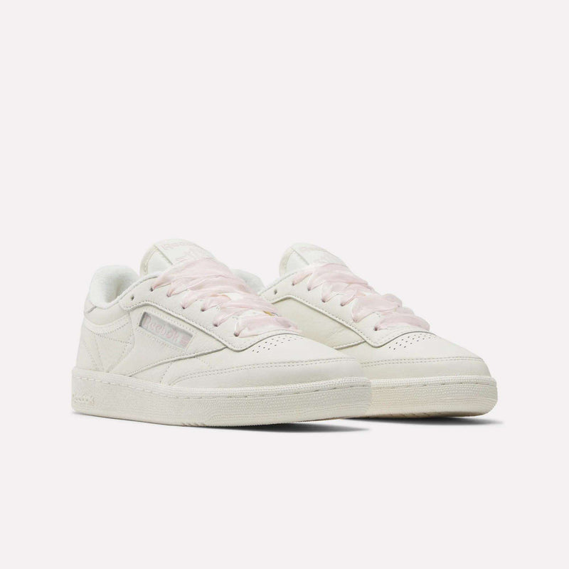 The Reebok Women's Club C 85 Vintage Shoes feature off-white leather, light pink laces, and classic low-top design with subtle branding, offering versatile vintage style. Shown against a white background.