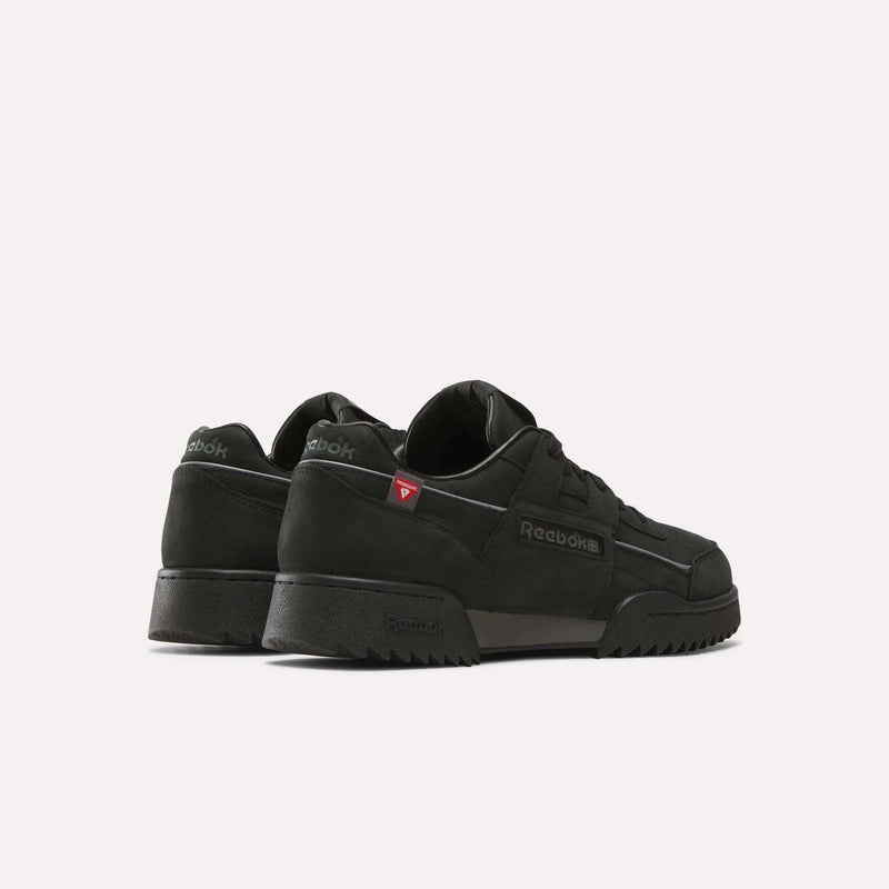 A pair of black Reebok Workout Plus Ripple Shoes with low tops and textured ripple soles, shown at an angle to highlight the sides and back. These weather-ready sneakers feature subtle branding, including a small red triangle logo near the heel.