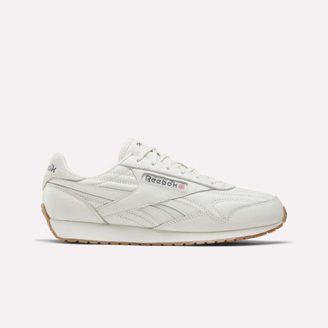 A Reebok Women's Classic AZ Shoe in Chalk/Chalk/Gum features a leather upper, gum sole, side branding, and stitched details—shown from a side view against a plain light background—capturing the enduring style of Reebok women's footwear.