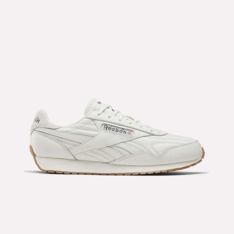 A Reebok Women's Classic AZ Shoe in Chalk/Chalk/Gum features a leather upper, gum sole, side branding, and stitched details—shown from a side view against a plain light background—capturing the enduring style of Reebok women's footwear.