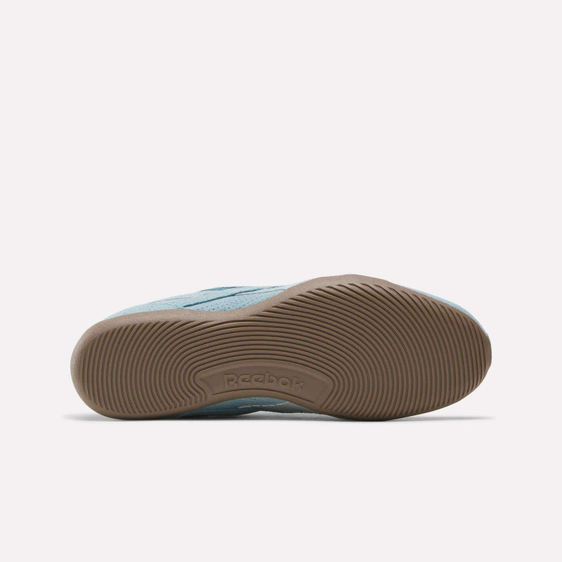 The image displays the sole of a Women’s Ultra Lo Shoe by Reebok in light blue, featuring a tan rubber outsole with curved textured lines and the Reebok logo embossed near the arch.