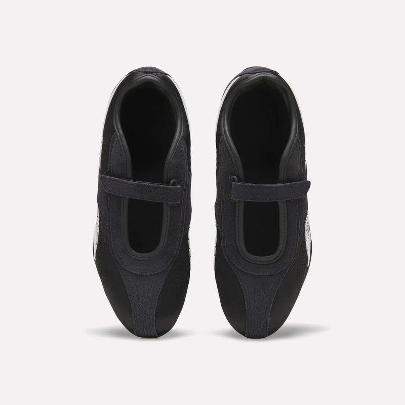 Top view of Reebok Women's Ultra Lo Mary Jane Shoes in black, featuring a single velcro strap on each, displayed side by side on a plain white background.