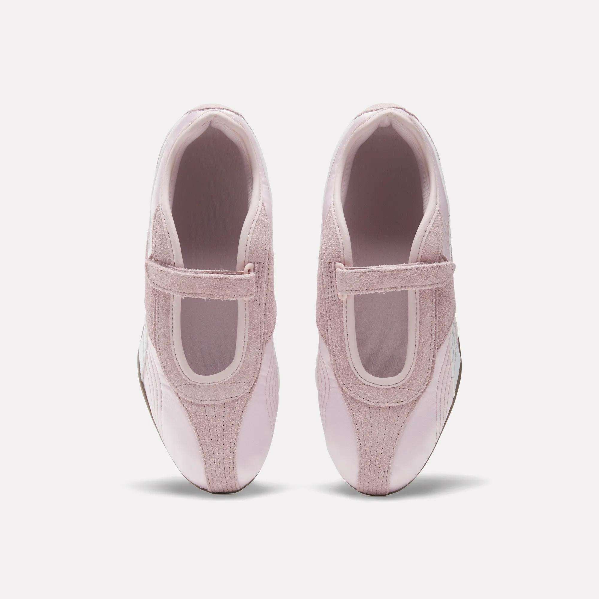 A pair of Women's Ultra Lo Mary Jane Shoes by Reebok in light pink with velcro straps, styled as low-profile runners, shown from above on a plain white background.