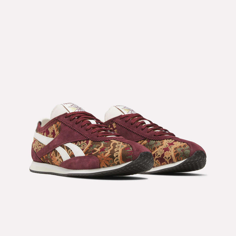 Introducing the Reebok R400 Shoes: this premium pair features maroon suede overlays and a vibrant, intricate tapestry pattern. With signature white side stripes and durable rubber soles, these sneakers showcase heritage-inspired style against a plain white backdrop.