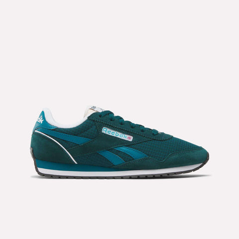 A teal Women's Classic AZ Shoes sneaker by Reebok with blue accents, white lining, black outsole, and side Reebok logo is displayed against a plain white background, capturing the authentic retro running shoe vibe.