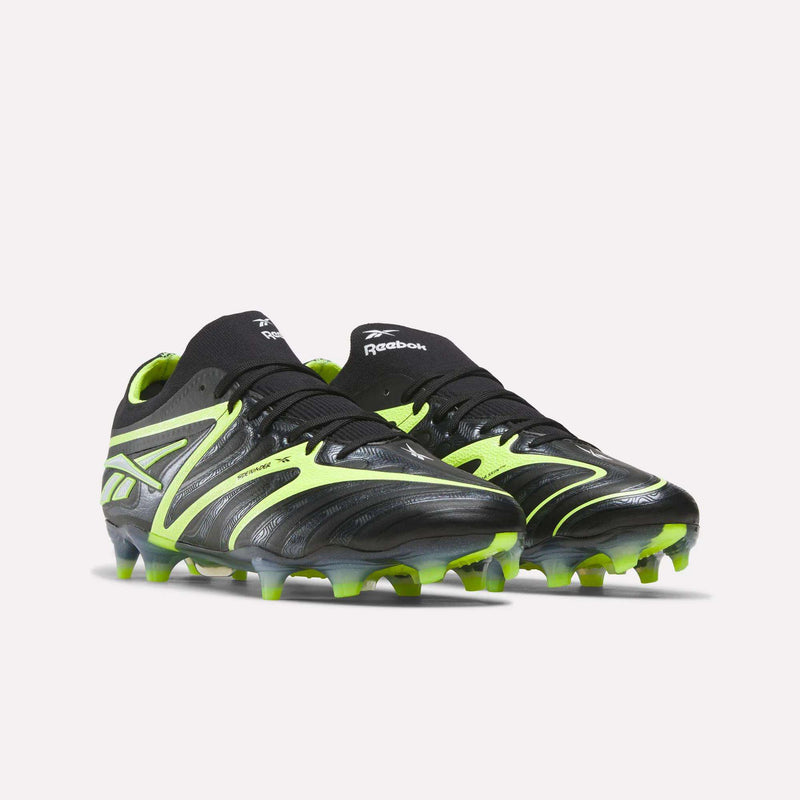 The Reebok Sidewinder 26 Elite FG Cleats in black and neon green feature textured uppers for enhanced ball control and molded studs, making them ideal for firm grass play. Shown on a light background.