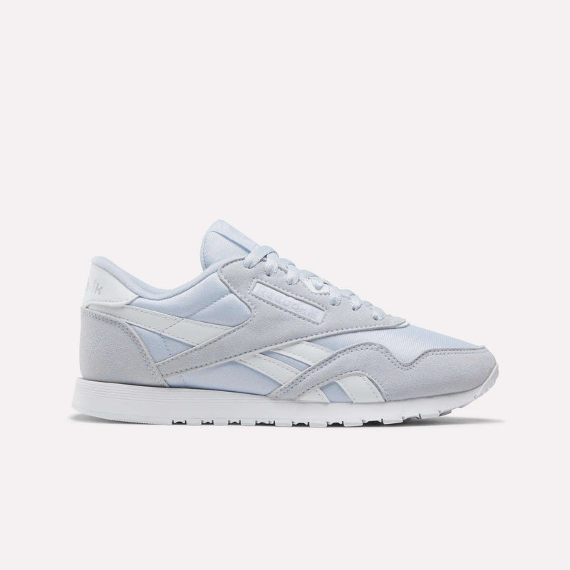 The Reebok Women's Classic Nylon Shoes in Tranquil Blue and White feature a timeless design with a lace-up front, white midsole, and durable rubber outsole—an ideal addition to any women's shoe collection, showcased against a plain white background.