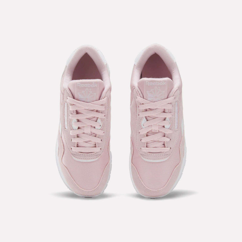 A pair of Reebok Women's Classic Nylon Shoes in light pink is viewed from above, highlighting the laces, tongue with the Reebok logo, and white soles, all set against a plain white background.