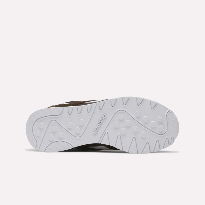 The image displays the textured white sole of the Reebok Women’s Classic Nylon Shoes, viewed from below against a plain light backdrop. The center of the sole is embossed with the Reebok logo, highlighting the vintage-inspired style characteristic of this sneaker.