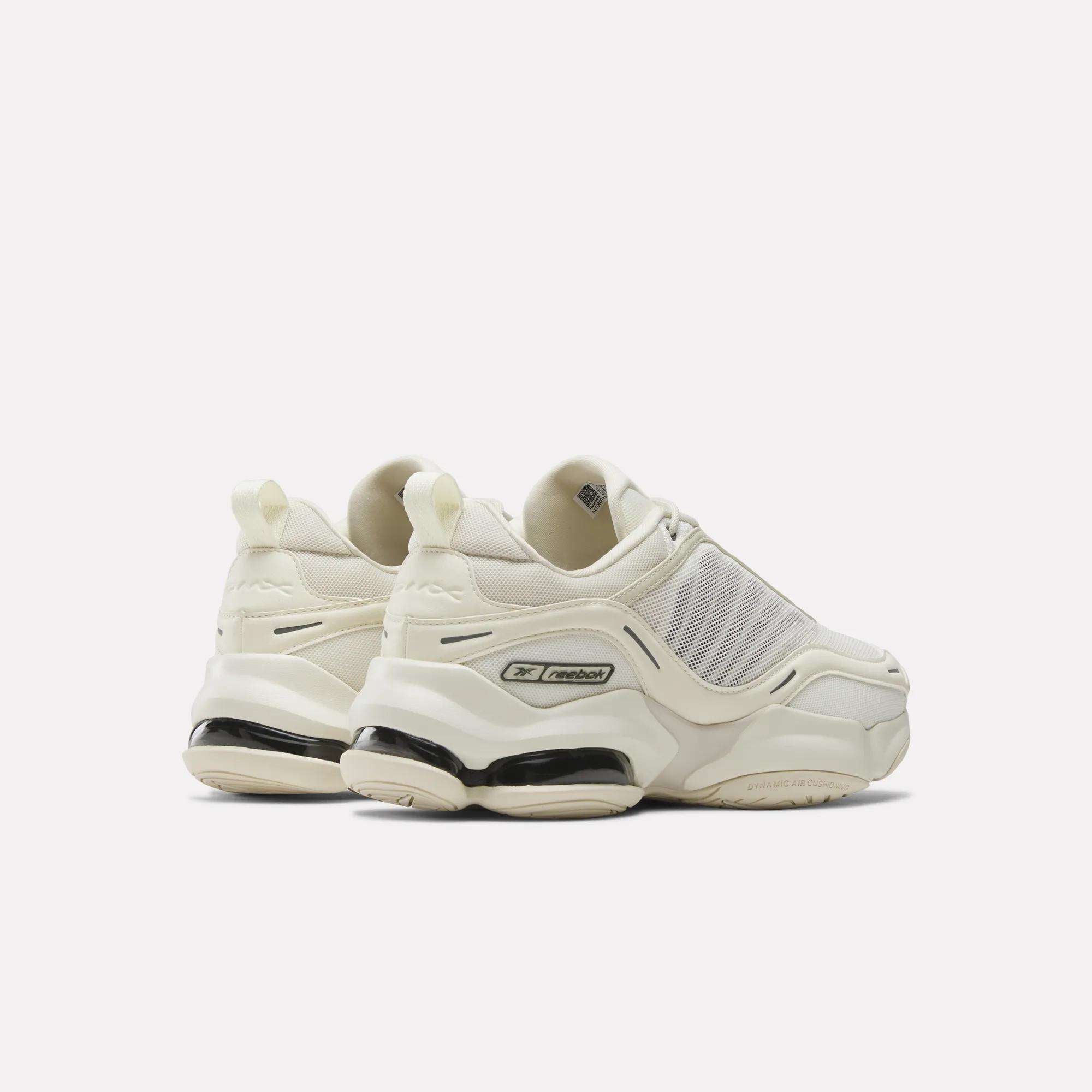 A pair of chunky, off-white Reebok DMX Series 3000 Shoes with thick soles and mesh panels, featuring DMX moving air technology for comfort, are positioned facing away on a plain white background.