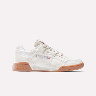 The Reebok x Hed Mayner Workout Plus OG Shoes feature a beige leather upper, gum sole, tan laces, and a Reebok logo with a UK flag on the side. This fitness-inspired sneaker is shown from the side against a plain light background.