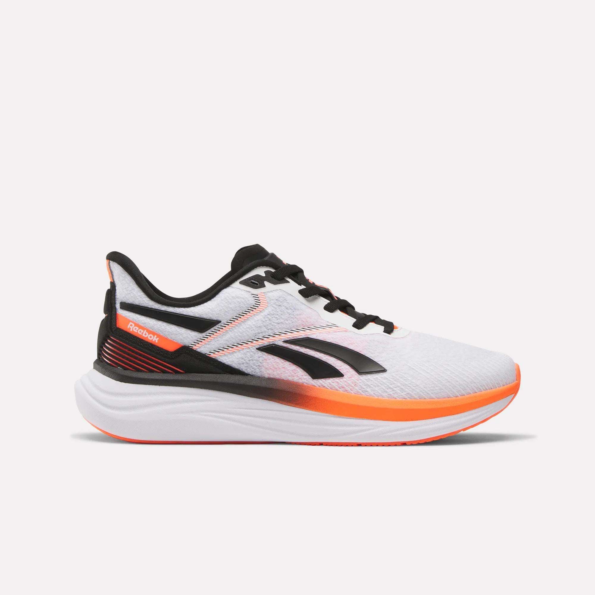 The Men's Viva Speed Shoes by Reebok feature a white design with black laces, a black logo, orange accents, and extra cushioning for comfort. This breathable athletic shoe is displayed in profile on a plain white background.