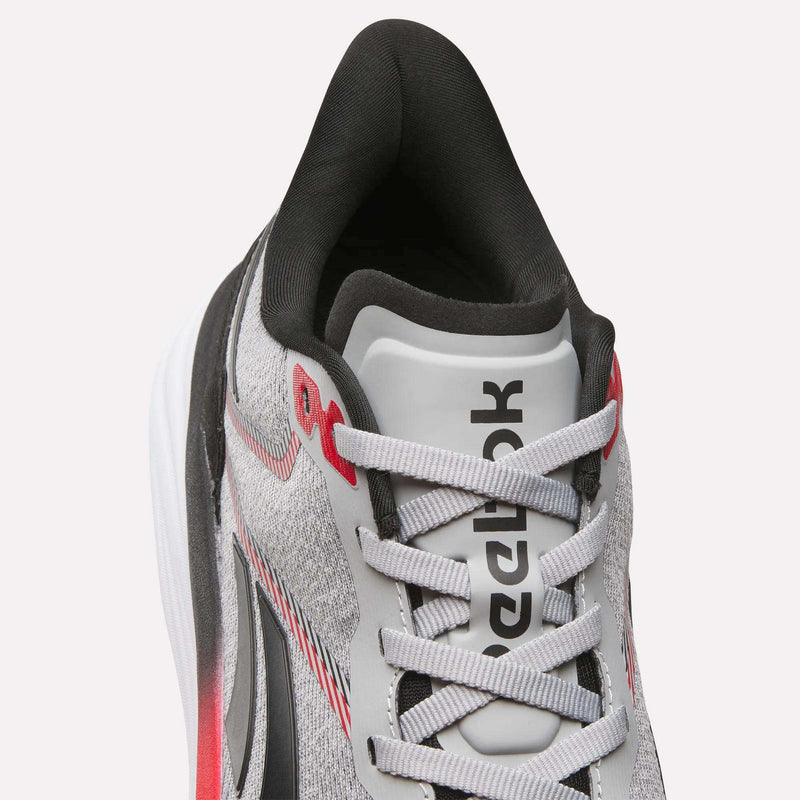 Close-up top view of the Reebok Men's Viva Speed Shoes in gray and white with black and red accents, featuring a breathable mesh upper, visible laces, and a cushioned interior for added comfort.
