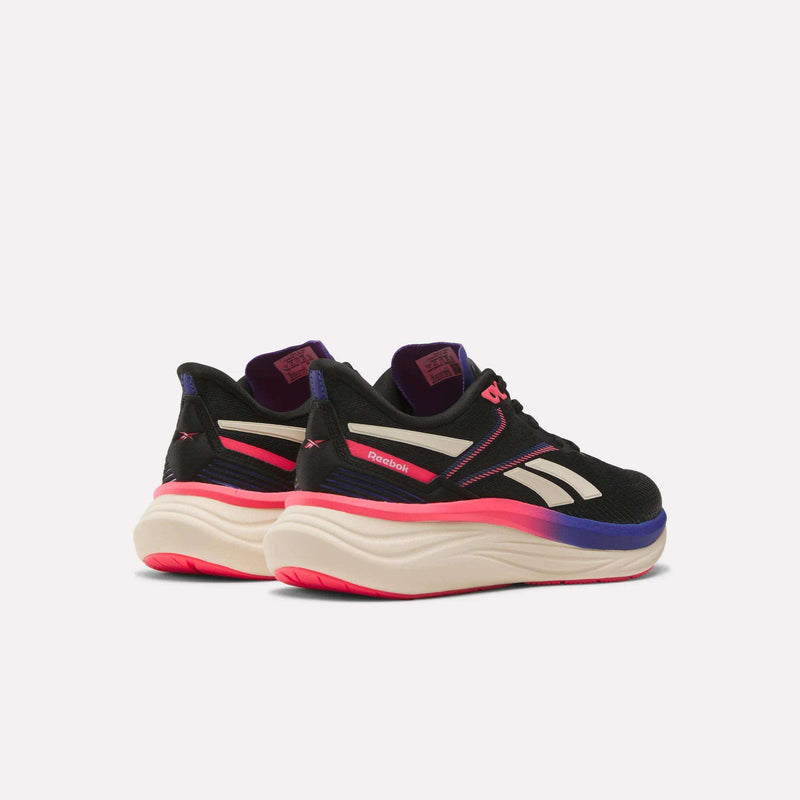 The Reebok Women's Viva Speed Shoes in black, white, and pink feature thick white and pink gradient soles with extra cushioning for comfort, displayed from back and side angles on a plain white background.