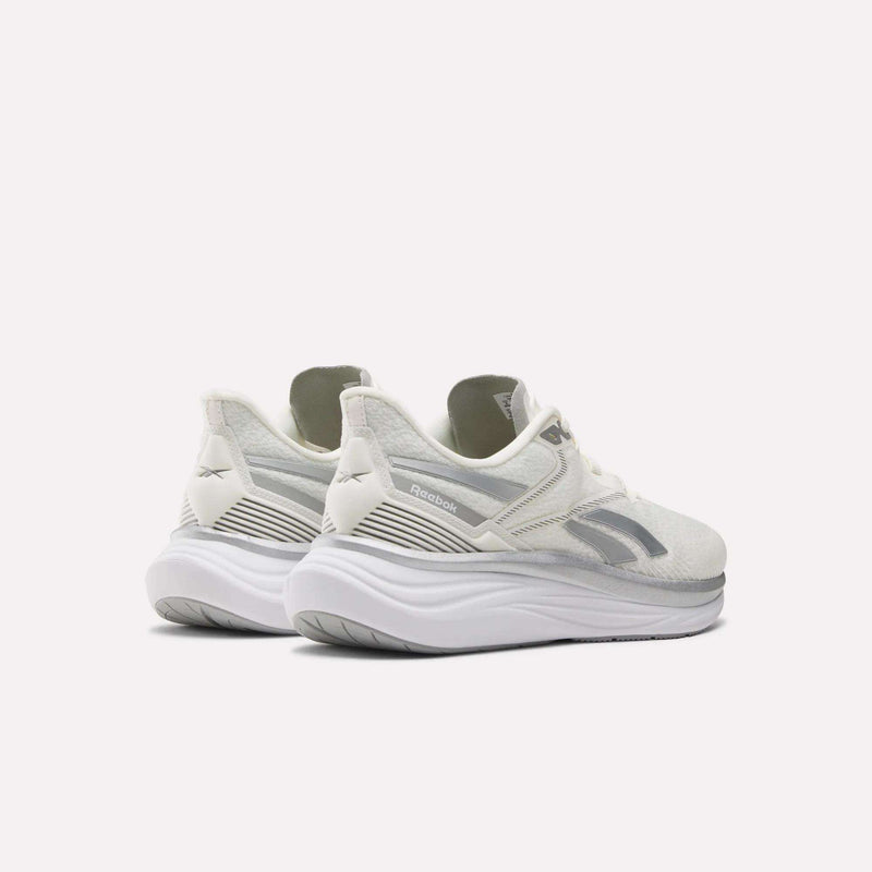A pair of Reebok Men's Viva Speed Shoes in white, featuring thick curved soles and extra cushioning, is displayed from a rear three-quarter view against a plain light background.