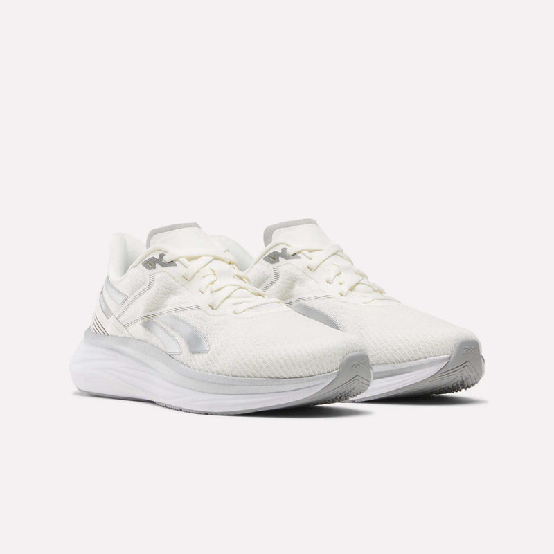 The Reebok Men's Viva Speed Shoes feature breathable white mesh uppers, subtle silver logo accents, white laces, and thick textured soles with extra cushioning, all showcased against a plain white background.