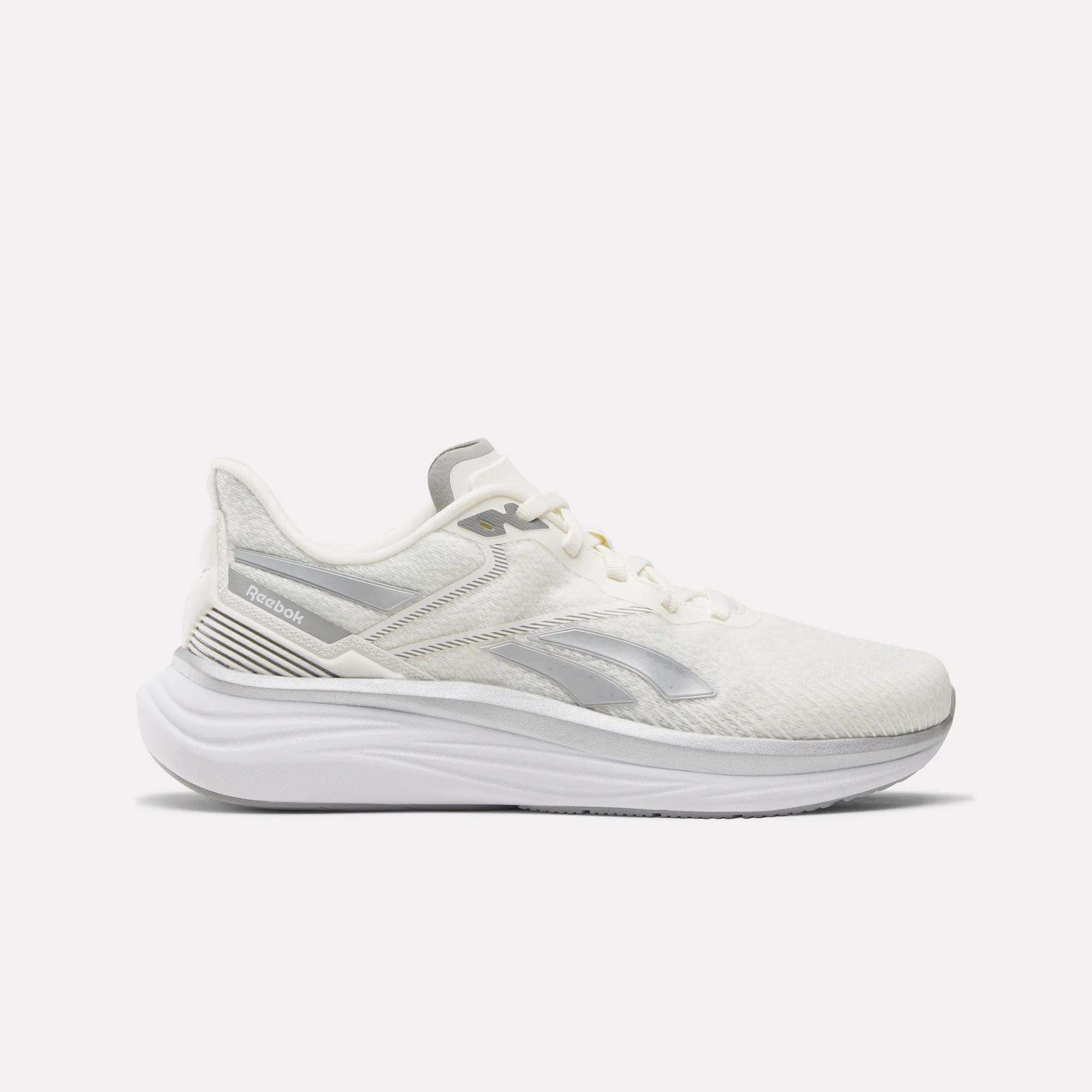 The Reebok Men's Viva Speed Shoes feature a white mesh upper for breathability, subtle gray Reebok logo, white laces, and a thick cushioned sculpted sole—shown in side profile on a white background.