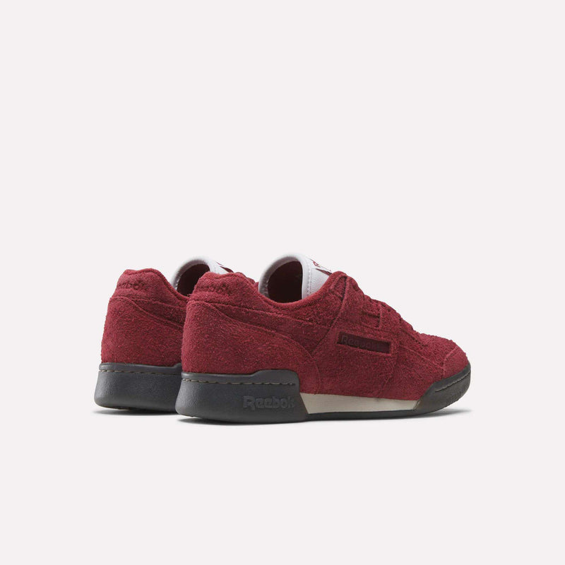 The Reebok Workout Plus Shoes feature maroon suede uppers, dark gray soles, and classic '80s style, shown from the back and side against a white background.