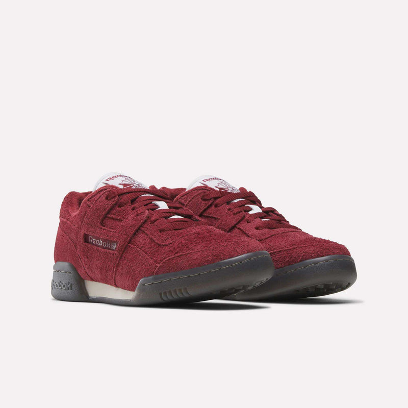 Reebok Workout Plus Shoes in maroon feature textured suede uppers, black rubber soles, and white tongue labels, delivering authentic '80s fitness style on a plain white background.