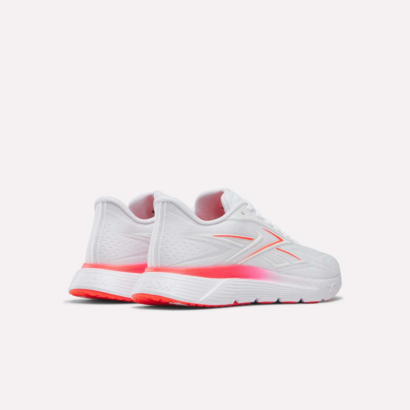 A pair of Reebok Women's Nano Gym 2.0 Training Shoes in white with pink accents on the logo, heel, and sole, displayed from a rear-side angle against a plain light background.