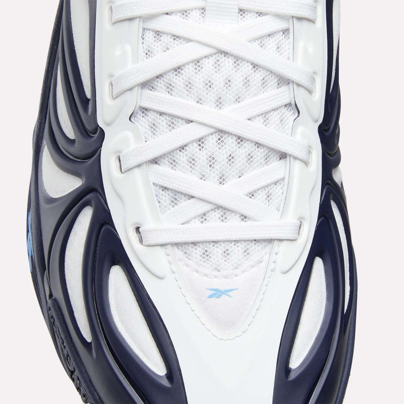 Close-up of the Reebok Angel Reese 1 Basketball Shoes in white with navy blue and black accents, featuring the Energy Return System for comfort. Mesh tongue, white laces, and a small blue Reebok logo complete this performance basketball shoe.