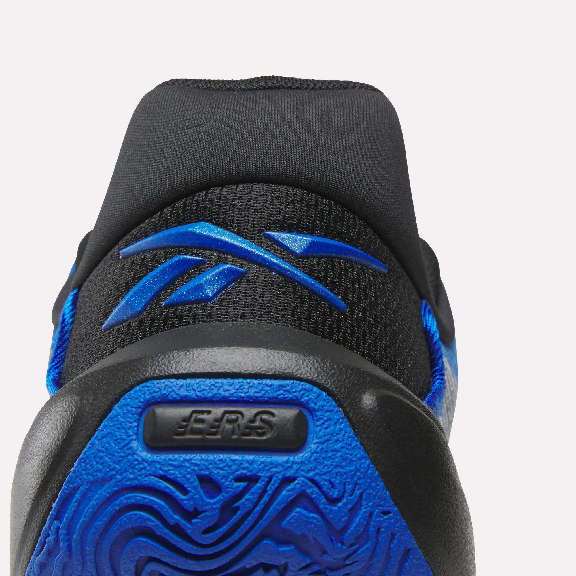 Close-up of the heel on Reebok Engine A 26 Basketball Shoes, showing a textured blue sole with ERS for energy return and a blue Reebok logo on the black fabric upper.
