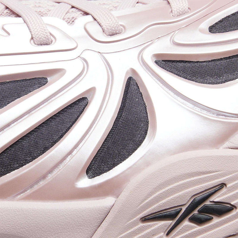 Close-up of the light pink Angel Reese 1 Basketball Shoes by Reebok, featuring textured fabric, sculpted glossy overlays, dark mesh inserts, and the Reebok logo near the sole—highlighting the Energy Return System for enhanced basketball performance.